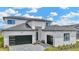 Modern home featuring a black garage door, monochromatic color scheme, and paver driveway at 32347 Wetland Bird Vw, San Antonio, FL 33576