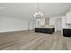 Bright open-plan kitchen with black island, modern appliances, white cabinets, and stylish chandelier at 32347 Wetland Bird Vw, San Antonio, FL 33576