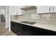 Modern kitchen with white countertops, black cabinetry, and stainless steel hood at 32347 Wetland Bird Vw, San Antonio, FL 33576
