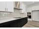 Modern kitchen with white countertops, black cabinetry, and stainless steel hood at 32347 Wetland Bird Vw, San Antonio, FL 33576
