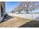 The backyard features well-maintained lawn space and a white privacy fence and shade trees at 37850 Prairie Rose Loop, Zephyrhills, FL 33542