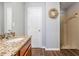 Bathroom featuring granite countertops, wood cabinets, a walk-in shower, and tiled floors for a modern touch at 37850 Prairie Rose Loop, Zephyrhills, FL 33542