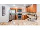 Kitchen with wood cabinetry, stainless steel appliances, granite countertops, and a stainless steel sink at 37850 Prairie Rose Loop, Zephyrhills, FL 33542