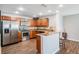Well-lit kitchen featuring stainless steel appliances, wood cabinets, granite countertops, and dark wood floors at 37850 Prairie Rose Loop, Zephyrhills, FL 33542