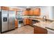 Kitchen with stainless steel appliances, wood cabinets, granite countertops, and tiled backsplash at 37850 Prairie Rose Loop, Zephyrhills, FL 33542