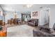 Open-concept living room featuring wood-look tile flooring, neutral walls, and natural light at 37850 Prairie Rose Loop, Zephyrhills, FL 33542