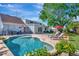 Lovely backyard with a sparkling pool, patio furniture, and privacy landscaping at 4711 Travertine Dr, Tampa, FL 33615