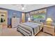 Relaxing blue bedroom with a bright window, neutral carpet, and comfortable furnishings at 4711 Travertine Dr, Tampa, FL 33615