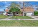 Charming two-story home with a well-manicured lawn, mature trees, and a two-car garage at 4711 Travertine Dr, Tampa, FL 33615