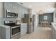 Modern kitchen with stainless steel appliances, custom cabinetry, and an adjacent dining area at 4711 Travertine Dr, Tampa, FL 33615
