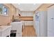 Well-lit laundry area with storage cabinets, washer, dryer and adjacent refrigerator at 4711 Travertine Dr, Tampa, FL 33615