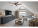 Cozy attic living room with vaulted ceilings, large TV, a sectional sofa, and a light color scheme at 4711 Travertine Dr, Tampa, FL 33615