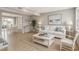 Bright living room with beach themed decor, hardwood floors, white sofa, and view into the dining area at 4711 Travertine Dr, Tampa, FL 33615