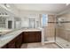 Spacious bathroom features double vanity with granite countertops and a walk-in shower with tile surround at 5027 Autumn Ridge Dr, Wesley Chapel, FL 33545