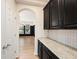 Kitchen with granite counters, dark cabinets, subway tile backsplash and an opening to a dining room at 5027 Autumn Ridge Dr, Wesley Chapel, FL 33545
