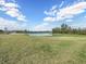 Neighborhood pond with manicured lawn and green space with lush trees in a picturesque planned community at 5027 Autumn Ridge Dr, Wesley Chapel, FL 33545