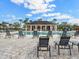 Community pool with lounge chairs and a clubhouse under a blue, partly cloudy sky at 5027 Autumn Ridge Dr, Wesley Chapel, FL 33545