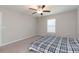 Bright bedroom with a ceiling fan, neutral carpet, and a window letting in natural light at 5446 Blue Azure Dr, Wimauma, FL 33598