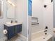 Well-lit bathroom featuring a navy vanity and a shower/tub with white tile at 6030 Printery St # 107, Tampa, FL 33616