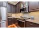Modern kitchen features stainless steel appliances, dark cabinets, granite counters and tile backsplash at 6030 Printery St # 107, Tampa, FL 33616