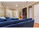 A living room with hardwood floors, a blue sectional sofa, built-in shelving, and natural light from shuttered windows at 6030 Printery St # 107, Tampa, FL 33616