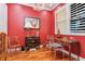 An office space with rich red walls, wood flooring and a decorative chandelier at 6030 Printery St # 107, Tampa, FL 33616