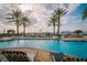 Gorgeous waterfront pool with lounge chairs overlooking the marina with swaying palm trees and glistening boats at 6030 Printery St # 107, Tampa, FL 33616