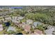 Wide aerial view of a neighborhood, highlighting houses, a swimming pool, pond, and lush landscaping at 7631 Sailwinds Pass, Port Richey, FL 34668