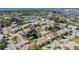 Bird's eye view of a residential area with houses, a swimming pool, and a pond nestled within greenery at 7631 Sailwinds Pass, Port Richey, FL 34668