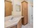 Bathroom boasts wood cabinets and a tiled shower next to a vanity with a large mirror at 7631 Sailwinds Pass, Port Richey, FL 34668