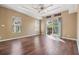 Large bedroom with hardwood floors, tray ceiling, and sliding doors to a balcony at 7631 Sailwinds Pass, Port Richey, FL 34668