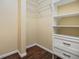 Walk-in closet includes white shelving and drawers, with wood-look floors and wire shelves at 7631 Sailwinds Pass, Port Richey, FL 34668