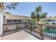 The wooden deck offers picturesque views of the water, palm trees, and neighboring building at 7631 Sailwinds Pass, Port Richey, FL 34668