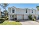 Charming townhome featuring a two-car garage, a well-manicured lawn, and a welcoming double-door entrance at 7631 Sailwinds Pass, Port Richey, FL 34668