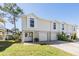 Charming townhome featuring a two-car garage, freshly cut lawn, and inviting double-door entrance at 7631 Sailwinds Pass, Port Richey, FL 34668