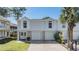 Charming townhome featuring a two-car garage, a well-manicured lawn, and a welcoming double-door entrance at 7631 Sailwinds Pass, Port Richey, FL 34668
