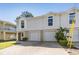 Inviting townhouse featuring a two-car garage, well-kept lawn, and a double door entry at 7631 Sailwinds Pass, Port Richey, FL 34668
