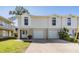 Inviting townhouse featuring a two-car garage, manicured lawn, and a double door entry at 7631 Sailwinds Pass, Port Richey, FL 34668