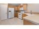 Bright kitchen with white appliances, wood cabinets, and tile flooring at 7631 Sailwinds Pass, Port Richey, FL 34668