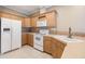 Modern kitchen features white appliances, wood cabinets, and ample counter space at 7631 Sailwinds Pass, Port Richey, FL 34668