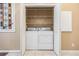 Washer and dryer inside a closet with bi-fold doors and wire shelving above appliances at 7631 Sailwinds Pass, Port Richey, FL 34668