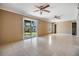 Bright, expansive living room with tile flooring, ceiling fans, and sliding doors leading to the outdoors at 7631 Sailwinds Pass, Port Richey, FL 34668