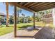 Covered patio with serene view of the lawn, water, trees, and surrounding neighborhood at 7631 Sailwinds Pass, Port Richey, FL 34668