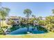 Beautiful view of coastal homes nestled around a serene pond with tropical landscaping and clear blue skies at 7631 Sailwinds Pass, Port Richey, FL 34668