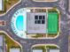 A top-down aerial view of a community pool and tennis court nestled among residential buildings at 7816 38Th N Ter # 7816, St Petersburg, FL 33709