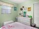 Bright bedroom features a window, light green paint, and a light-colored wicker dresser at 7816 38Th N Ter # 7816, St Petersburg, FL 33709