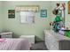 Bright bedroom features a window, light green paint, and a light-colored wicker dresser at 7816 38Th N Ter # 7816, St Petersburg, FL 33709