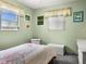 Bright bedroom features two windows, light green paint, and light-colored wicker decor at 7816 38Th N Ter # 7816, St Petersburg, FL 33709