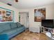 Comfortable living room featuring a blue sofa, tile flooring, and neutral wall paint at 7816 38Th N Ter # 7816, St Petersburg, FL 33709