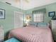 Cozy bedroom with pastel green walls and light-colored wicker furniture at 7816 38Th N Ter # 7816, St Petersburg, FL 33709